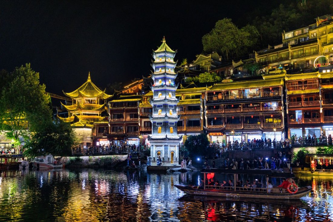 凤凰古城万名塔的沱江夜景，金色灯火映在水面